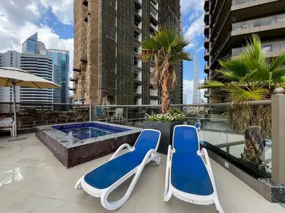 two lounge chairs and a pool on the roof of a building at Modern Studio Downtown Dubai Luxury & Convenience in Dubai