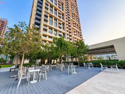 a patio with tables and chairs in front of a building at Stunning 3BR Burj Fountain view & Dubai Mall in Dubai