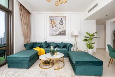 a living room with green couches and a table at Stylish 2BR with Boulevard View & 5 min from Dubai Mall in Dubai