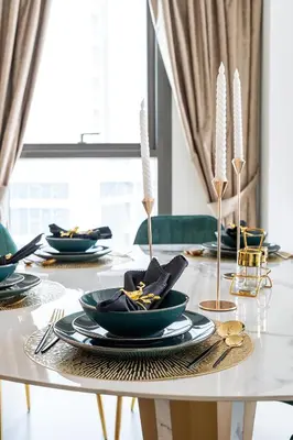 a dining room table with plates and utensils on it at Stylish 2BR with Boulevard View & 5 min from Dubai Mall in Dubai
