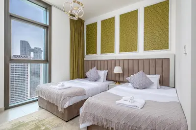 two beds in a hotel room with a window at Stylish 2BR with Boulevard View & 5 min from Dubai Mall in Dubai