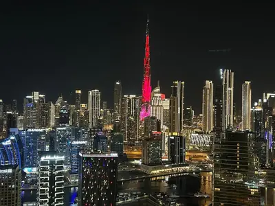 a night view of a large city with a red flag at Full Burj khalifa view 41 Floor in Dubai