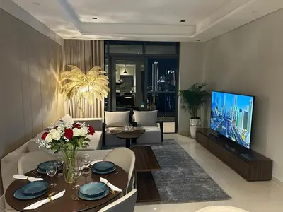 a living room with a couch and a tv at Full Burj khalifa view 41 Floor in Dubai