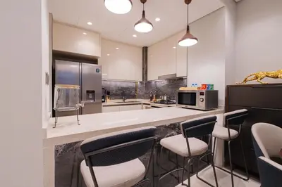 a kitchen with a counter with chairs and a microwave at Full Burj khalifa view 41 Floor in Dubai