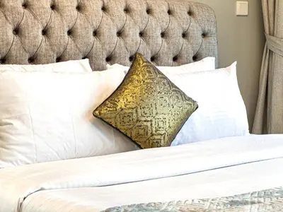 a bed with white sheets and a pillow on it at Modern 1BR in Business Bay - Balcony with Skyline Views in Dubai