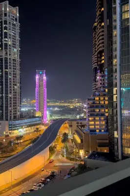 a view of a city at night with tall buildings at C Infinity Holiday Homes in Dubai Marina in Dubai