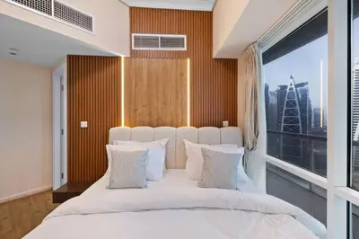 a bedroom with a large white bed with a large window at Elegant Haven and Spacious 2BR in Lake Terrace in Dubai