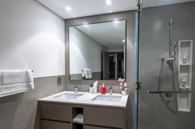 a bathroom with a sink and a shower with a mirror at Luxury Grande 2BR Near DubaiMall in Dubai