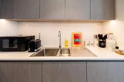 a kitchen with a sink and a microwave at Luxury Grande 2BR Near DubaiMall in Dubai