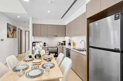 a kitchen and dining room with a table and a refrigerator at Luxury 2BR Apartment in Downtown Dubai in Dubai