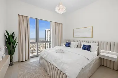 a bedroom with a large bed and a large window at Luxury 2BR Apartment in Downtown Dubai in Dubai