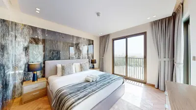 a bedroom with a bed and a large window at Jumeirah Golf Estate - Elegant Three Bed Villa in Dubai
