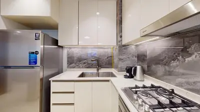 a kitchen with white cabinets and a stainless steel refrigerator at Vacationer I Vista 2 Bedroom I Business Bay I Free Parking, Pool, Gym & Wi-Fi in Dubai