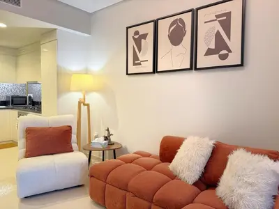 a living room with a couch and a chair at Cozy Two Bedroom Apartment in Dubai