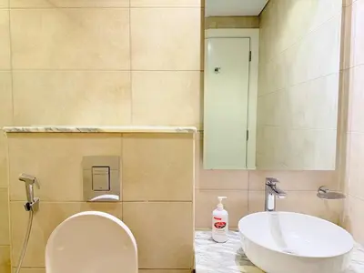 a bathroom with a toilet and a sink at Cozy Two Bedroom Apartment in Dubai