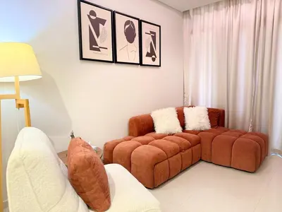 a living room with a couch and two chairs at Cozy Two Bedroom Apartment in Dubai