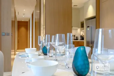 a long white table with glasses and bowls on it at Luxury 3BR Apartment with Burj Khalifa Views - Address Opera in Dubai