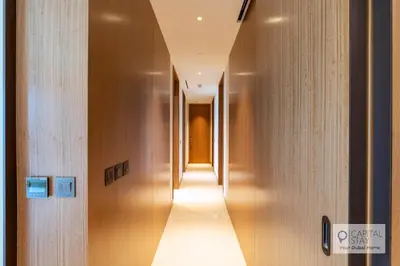 a hallway with wooden walls and a long corridor at Luxury 3BR Apartment with Burj Khalifa Views - Address Opera in Dubai