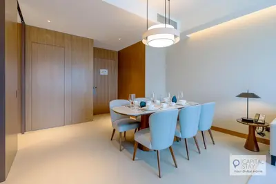 a dining room with a table and blue chairs at Luxury 3BR Apartment with Burj Khalifa Views - Address Opera in Dubai