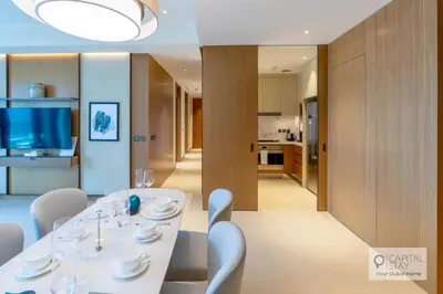 a dining room with a white table and chairs at Luxury 3BR Apartment with Burj Khalifa Views - Address Opera in Dubai