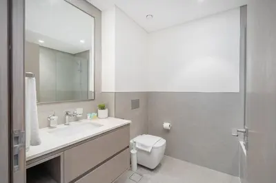 a bathroom with a sink and a toilet and a mirror at Lux 3 BR & Maidroom Burj & Fountain View 1Gbps WIFI in Dubai