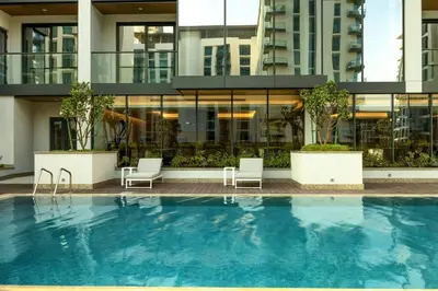 a swimming pool with two chairs and a building at STAY BY LATINEM Luxury 1BR Holiday Home OPA2401 near Burj Khalifa in Dubai