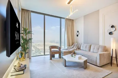 a living room with a couch and a large window at STAY BY LATINEM Luxury 1BR Holiday Home OPA2401 near Burj Khalifa in Dubai