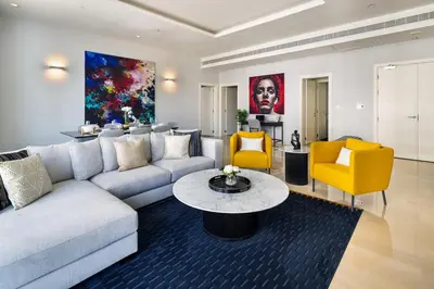 a living room with a couch and a table and chairs at 4BR Oceana Residences - Beach and Pool Access in Dubai