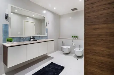 a bathroom with a toilet and a sink and a mirror at 4BR Oceana Residences - Beach and Pool Access in Dubai