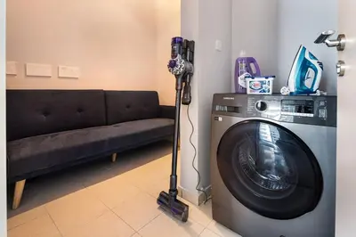 a living room with a washing machine and a couch at 4BR Oceana Residences - Beach and Pool Access in Dubai