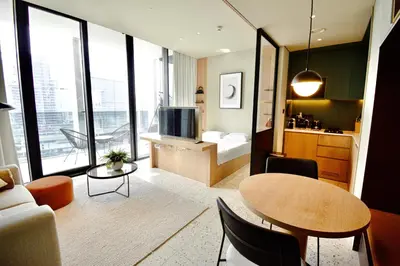 a living room with a table and a room with a bed at Modern Studio at Upside Living, Business Bay with Burj Khalifa View in Dubai