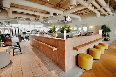 a lobby with a bar with yellow stools at Modern Studio at Upside Living, Business Bay with Burj Khalifa View in Dubai