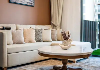 a living room with a couch and a coffee table at Royal Vista - Luxury 1BR Apartments at Kensington Waters in Dubai