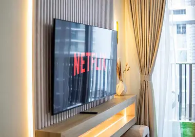 a flat screen tv sitting on top of a entertainment center at Royal Vista - Luxury 1BR Apartments at Kensington Waters in Dubai