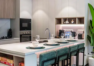 a kitchen with a table with plates and wine glasses at Royal Vista - Luxury 1BR Apartments at Kensington Waters in Dubai