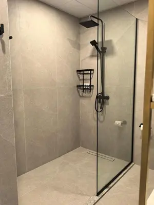 a shower with a glass door in a bathroom at Air Homes - Stylish Urban Living in a Modern 1BR in Dubai