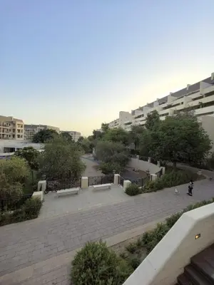 a park with benches in front of a building at Air Homes - Stylish Urban Living in a Modern 1BR in Dubai