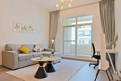 a living room with a couch and a table at Air Homes - Stylish Urban Living in a Modern 1BR in Dubai