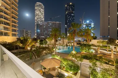 a view of a city at night with a pool at Garden Hideaway 2BR Boho Duplex Resort Living in Dubai