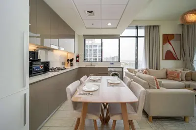 a kitchen and living room with a table and a couch at PVH - Stylish 1BR Near Dubai Mall - Azizi Riviera in Dubai