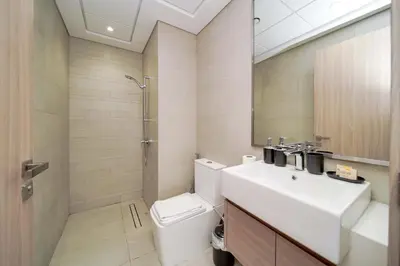 a bathroom with a toilet and a sink and a shower at PVH - Stylish 1BR Near Dubai Mall - Azizi Riviera in Dubai