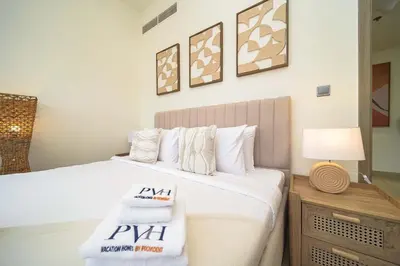 a bedroom with a bed with towels on it at PVH - Stylish 1BR Near Dubai Mall - Azizi Riviera in Dubai