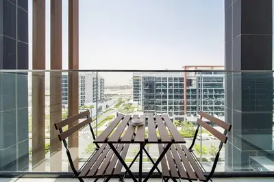 a wooden table and two chairs on a balcony at PVH - Stylish 1BR Near Dubai Mall - Azizi Riviera in Dubai