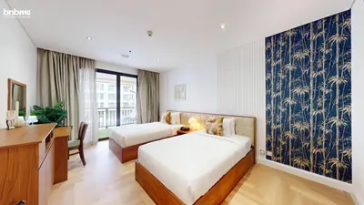 a hotel room with two beds and a desk and a window at bnbme - Luxury Anantara Palm Apt Beachfront Lagoon Pools Balcony & Spa Access in Dubai
