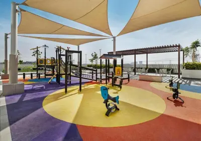 a play area with a playground with swings at Bespoke Holiday Homes - Studio with Modern Amenities in Azizi Riviera in Dubai