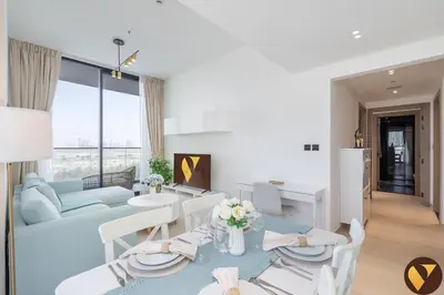 a living room with a couch and a table and chairs at Vogue JVC Binghatti Corner near Circle Mall, Two Bedroom Apartment with Balcony and City View, Access to all Amenities in Dubai