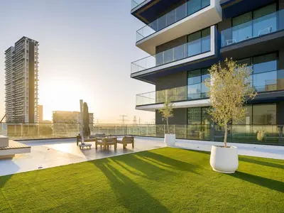 a building with a yard with benches and a tree at Vogue JVC Binghatti Corner near Circle Mall, Two Bedroom Apartment with Balcony and City View, Access to all Amenities in Dubai