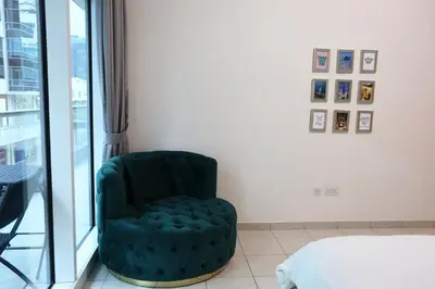 a green chair in a room with a window at Nivis find- Luxury 1 BHK nearby Dubai Mall in Dubai