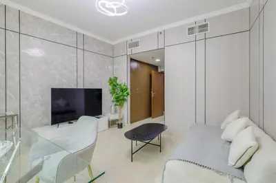 a living room with a couch and a tv at Prime Downtown Male Dormitory Comfort Meets Convenience in Dubai