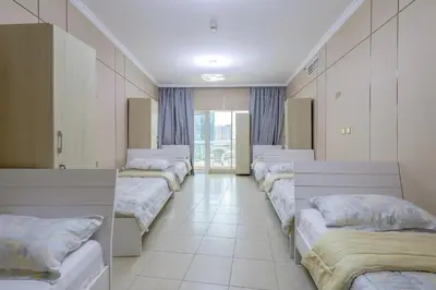 a row of beds in a row in a room at Prime Downtown Male Dormitory Comfort Meets Convenience in Dubai